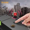 A hand is pressing an SOS button on a device, with a red alarm light flashing in the background of a destroyed city. Podgląd zdjęcia produktu