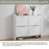 A white shoe cabinet with four flip-down compartments, placed against a white wall. Produktbild-Vorschau