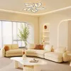 A modern living room with a curved sofa, coffee table, and a unique flower-shaped ceiling light. Náhled obrázku produktu