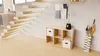 A modern living room with a wooden staircase, a shelving unit, and an umbrella stand. Produktbild-Vorschau
