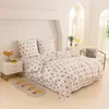 A neatly made bed with floral patterned bedding in a bright, airy room. Produktbild-Vorschau