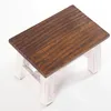 A small wooden stool with a dark brown top and white legs, shown from a top-down diagonal angle against a white background. Produktbild-Vorschau