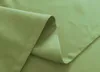 A close-up view of folded green fabric, likely curtains, showing stitching and texture. Produktbild-Vorschau