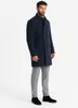 A man wearing a navy coat and gray pants, standing against a white background. Anteprima dell’immagine prodotto