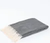 A folded gray herringbone blanket with cream fringe is displayed on a white background. Anteprima dell’immagine prodotto