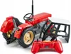 A red toy tractor with a remote control and a separate cabin structure, all on a white background. Náhľad obrázku produktu
