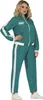 A woman wearing a teal tracksuit with white stripes, standing against a white background. Produktbild-Vorschau
