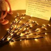 Decorative LED branches with lights on a wooden surface, with a stuffed toy and a paper bag in the background. Anteprima dell’immagine prodotto