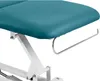 A close-up view of the side of a turquoise massage table, showing a metal towel rack attached underneath. Náhled obrázku produktu