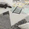 A close-up view of a children's rug with a playful animal design and geometric patterns. Produktbild-Vorschau