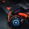 A gaming headset and keyboard are displayed on a dark surface. Voir les images du produit