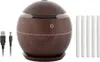 A dark wood-grain mini aroma diffuser with a USB cable and several white filter sticks. Produktbild-Vorschau