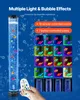A hand holding a remote control is shown next to a tall, illuminated bubble lamp with colorful fish inside. The background is a dark blue with water bubbles. The image also displays various color options for the lamp. Anteprima dell’immagine prodotto