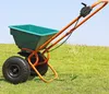 A garden spreader sits on a grassy hill with a blue sky in the background. Produktbild-Vorschau