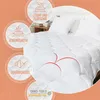 A white comforter is shown on a bed, with several circular overlays highlighting product features. Produktbild-Vorschau