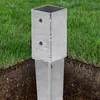 A metal post anchor is partially buried in the ground, with grass surrounding it. Produktbild-Vorschau