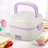 A white and purple electric lunchbox with a handle sits on a light wooden table, with toast and tomatoes in the foreground. Náhled obrázku produktu