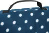 A close-up view of a blue picnic blanket with white polka dots, showing a black carrying strap. Náhled obrázku produktu