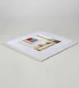 A white picture frame with a mat and a picture of a room with a painting on the wall. Produktbild-Vorschau