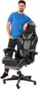 A man is standing next to a gaming chair. Produktbild-Vorschau