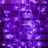 A close-up view of purple string lights against a wooden background. Produktbild-Vorschau