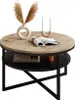 A round coffee table with a wood-look top and a black lower shelf, decorated with a vase of dried flowers, a book, and candles. Náhled obrázku produktu