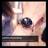 A woman's wrist wearing a rose gold watch with a starry blue dial. Produktbild-Vorschau