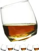 A set of whiskey glasses, with one glass filled with whiskey in the foreground and five empty glasses in the background. Podgląd zdjęcia produktu