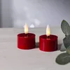 Two red LED candles with flickering flames sit on a light-colored surface, with a blurred background. Produktbild-Vorschau