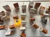 A collection of small, decorative houses and figures arranged on a white surface. Produktbild-Vorschau