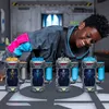 A young person is leaning over a table with several toy "mutator" containers, looking at them with a smile. The background appears to be a laboratory or workshop setting. Náhľad obrázku produktu