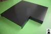 A dark gray metal corner piece for a wall covering is placed on a green surface. Produktbild-Vorschau