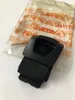 A black plastic part, likely a component for a chainsaw, rests on a white surface next to its original packaging. Produktbild-Vorschau