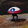 A small, spherical robot with two legs stands on a rocky, uneven surface. Anteprima dell’immagine prodotto
