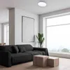 A modern living room with a black sofa, coffee table, and a large window. Podgląd zdjęcia produktu