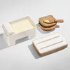 A butter dish with a block of butter inside, a lid, and two slices of toast with butter on a wooden spreader. Podgląd zdjęcia produktu
