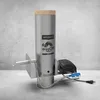 A stainless steel smoking generator with a wooden top and attached electric pump, set against a concrete wall. Produktbild-Vorschau