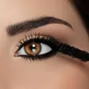A close-up shot of a person's eye with mascara being applied. Produktbild-Vorschau