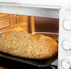 A loaf of bread is baking in a white oven. Produktbild-Vorschau