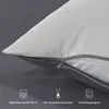 A close-up of a pillowcase showing a zipper and icons with text indicating product features. Voir les images du produit