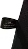 A close-up view of a black fabric tag attached to a dark textured material, likely a product. Náhled obrázku produktu