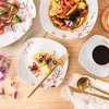 A table setting with plates, food, and coffee, decorated with cherry blossoms. Voir les images du produit