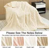 A plush blanket draped over a chair, with smaller inset images showing the blanket under different lighting conditions. Produktbild-Vorschau