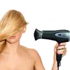 A woman with blonde hair is holding a black hairdryer. Produktbild-Vorschau