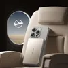 A phone case with a power bank attached, placed on an airplane seat next to a window showing a plane icon. Produktbild-Vorschau