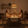 Two women are sitting at a dining table, enjoying a meal and conversation. Podgląd zdjęcia produktu