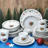 A Christmas-themed dinnerware set with gingerbread man and snowflake motifs, arranged with decorative trees and ornaments. Náhled obrázku produktu