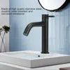 A black faucet is installed in a white sink, with blue tiled walls in the background. Produktbild-Vorschau