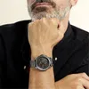 A man wearing a black shirt and a watch on his wrist. Náhľad obrázku produktu