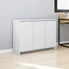 A white sideboard with three doors is shown in a room with a light gray textured wall and a light wood floor. Náhľad obrázku produktu